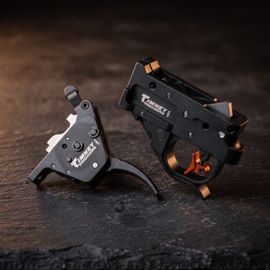 Timney CZ 457 and Calvin Elite rimfire triggers on dark slate, accompanying our bolt-action and rimfire trigger guide