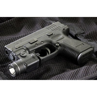 Streamlight TLR-3 light clamped to the accessory rail of a polymer-framed pistol